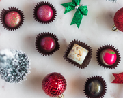 Assorted chocolates with festive decorations on a light background