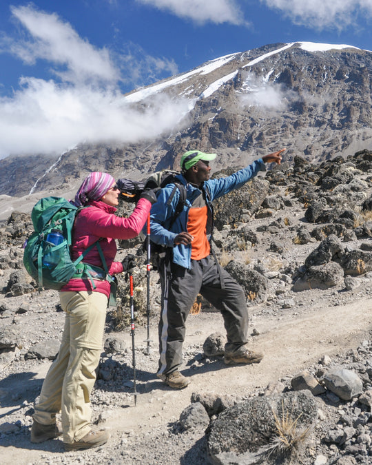 Phyllis and a gentleman trekking through the mountains